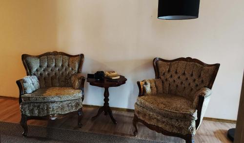 two chairs and a side table in a room at Hnatowe Berdo BB in Wetlina