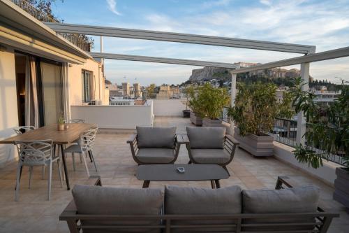 a patio with a table and chairs on a balcony at V&V Acropolis view apartment in Athens