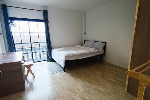 a small bedroom with a bed and a large window at Chubby 9 Standard room in Ban Bang Phlat