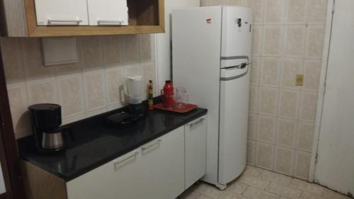 uma cozinha com um frigorífico branco num quarto em Casa Area Gourmet em Araruama