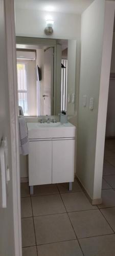 a bathroom with a white sink and a mirror at Del vino departamento in La Cieneguita