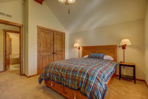 1 dormitorio con 1 cama con manta a cuadros en Tamarack Ski Resort Townhome - Elegant couple's retreat - Path to chairlift - Golf en Donnelly