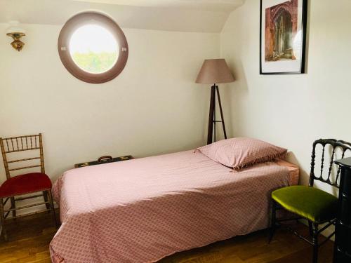 a bedroom with a bed and a window and a chair at Péniche sur la Seine pour les Jeux Olympiques 2024 à Paris in Choisy-le-Roi