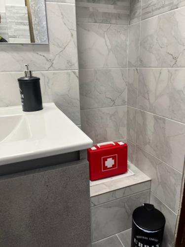 a bathroom with a sink and a red box on a shelf at Casa Leandra in Civitavecchia