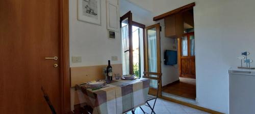 a kitchen with a table with a bottle of wine at Il melograno la casetta nel verde in Le Grazie