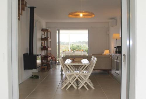 - une cuisine et une salle à manger avec une table et des chaises dans l'établissement Casa Menina do Mar in Carvalhal Beach, à Grândola