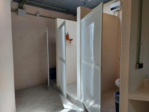 a bathroom with two open doors and a toilet at Elmar hostal in Bacalar