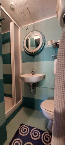 a bathroom with a sink and a toilet and a mirror at Il melograno la casetta nel verde in Le Grazie