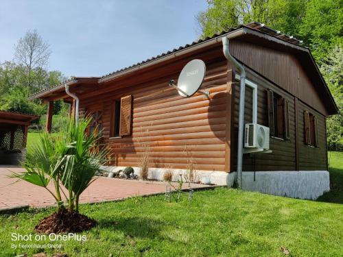 a log cabin with a grass yard in front of it at Ferienwohnung Grete, an der Weinstraße in Ehrenhausen