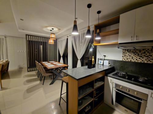 a kitchen with a table and a dining room at Staycation At Sandari Batulao Overlooking Spot in Tagaytay