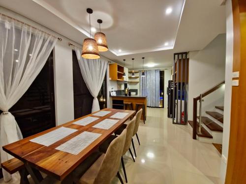 a dining room with a wooden table and chairs at Staycation At Sandari Batulao Overlooking Spot in Tagaytay