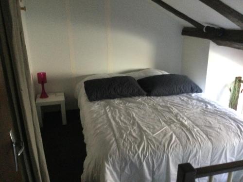 - une chambre avec un lit blanc et des oreillers dans l'établissement Old Boat, à Nancy