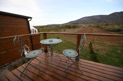 two chairs and a table on a wooden deck at Natura Bungalow in Ždrelo