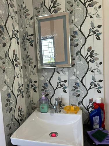 a bathroom with a sink and a mirror at Self Check In 1BHK Home fully Equipped Kitchen in Nagpur