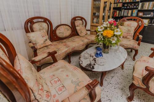una sala de estar con sillas y una mesa con un jarrón de flores en Casa Hotel Miriam, en Montería