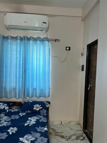 a bed in a room with a blue curtain at Self Check In 1BHK Home fully Equipped Kitchen in Nagpur