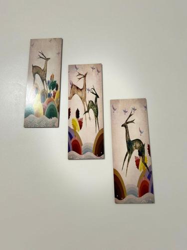 three paintings of giraffes and birds on a wall at Self Check In 1BHK Home fully Equipped Kitchen in Nagpur