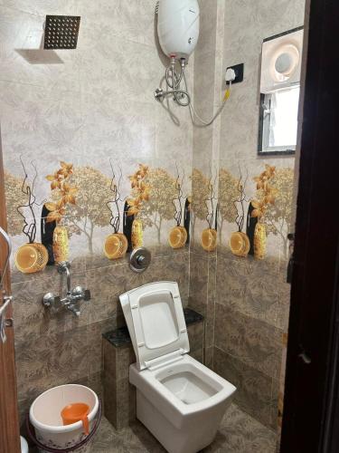 a bathroom with a toilet and vases on the wall at Self Check In 1BHK Home fully Equipped Kitchen in Nagpur