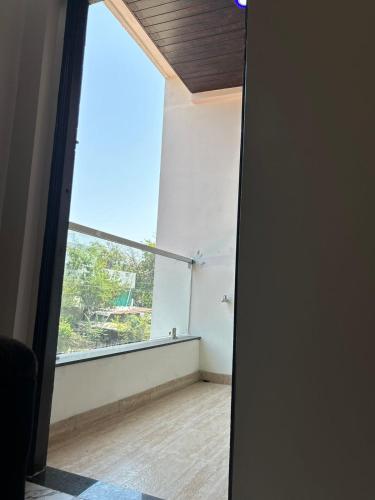 an open door to a room with a large window at Self Check In 1BHK Home fully Equipped Kitchen in Nagpur