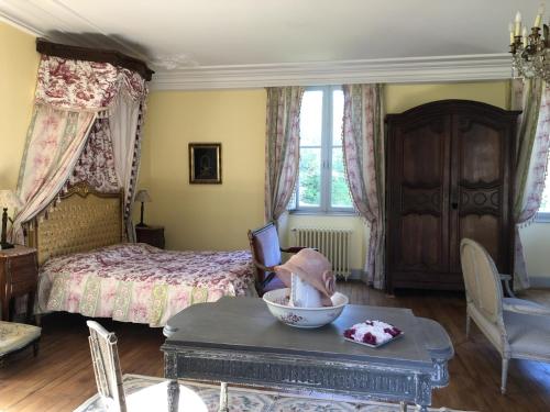 - une chambre avec un lit et une table avec un bol dans l'établissement Château de la Mothe, à Saint-Sulpice-en-Pareds