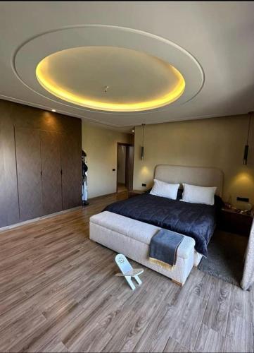 een slaapkamer met een groot bed en een groot plafond bij Maison FK in Casablanca