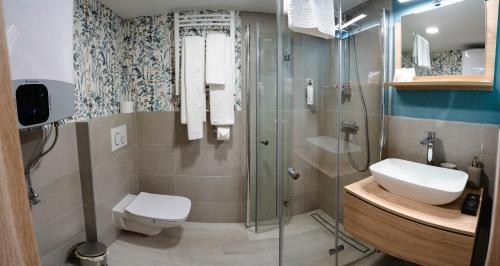 a bathroom with a shower and a toilet and a sink at Kalvin Apartments in Budapest