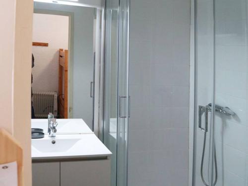 uma casa de banho com um chuveiro e um lavatório. em Studio Les Orres, 1 pièce, 4 personnes - FR-1-322-323 em Les Orres