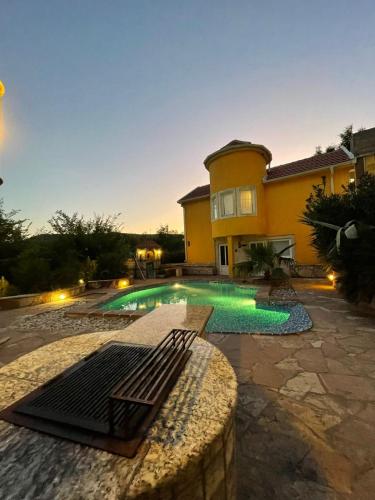 a swimming pool in front of a house at Yellow Villa With A Sea View in Budva