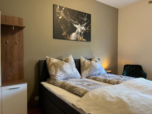 a bedroom with a bed and a picture of a deer at 3144 Ferien am SCHLOSS WALD Ap DAVINCI in Wald