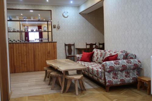 ein Wohnzimmer mit einem Sofa und einem Tisch in der Unterkunft guest house Merci in Tbilisi City