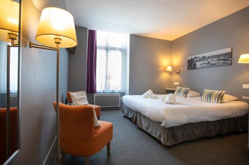 une chambre d'hôtel avec deux lits et une chaise dans l'établissement Au Bout Du Quai, à Granville