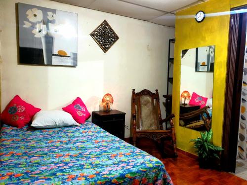 Un dormitorio con una cama con un edredón colorido. en SHALOM HOME, en Santa Ana