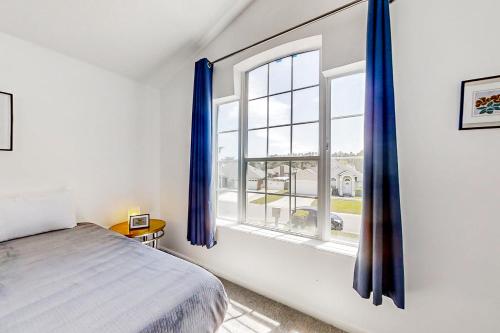 a bedroom with a bed and a window with blue curtains at Lagoon Escape in Jacksonville