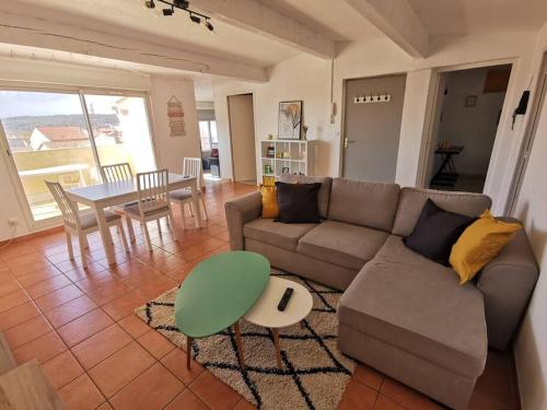 uma sala de estar com um sofá e uma mesa em Appartement avec terrasse Classé em Port-la-Nouvelle