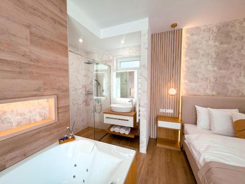 a bathroom with a tub and a bed and a sink at TWIN prémium apartman in Tihany