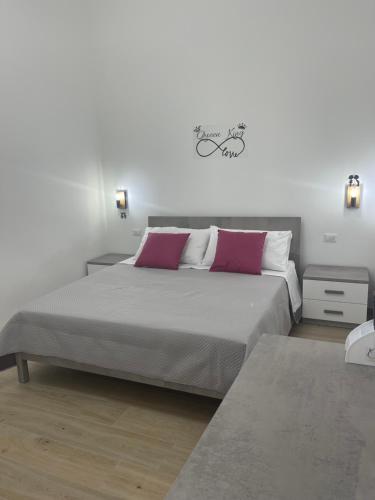 a bedroom with a large bed with two pink pillows at Sweet home-Casa Di Bari in Turi