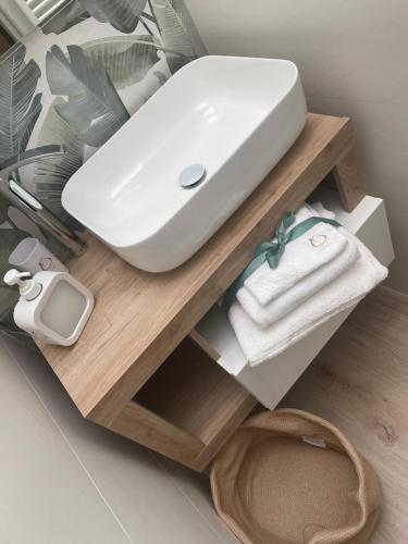 a white sink on a wooden shelf in a bathroom at Sweet home-Casa Di Bari in Turi