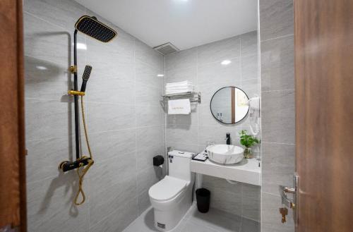 uma casa de banho com um WC, um lavatório e um espelho. em lucky life hotel em Ấp Nhât (2)