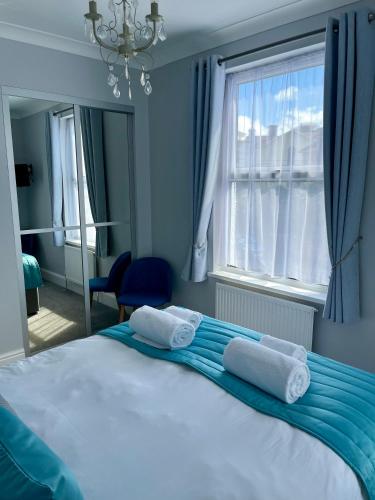 a bedroom with a large bed with towels on it at Bentley Lodge in Torquay