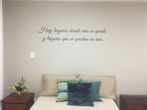 a bedroom with a bed with a quote on the wall at Ideal Apartaestudio con Piscina!!! in Dosquebradas