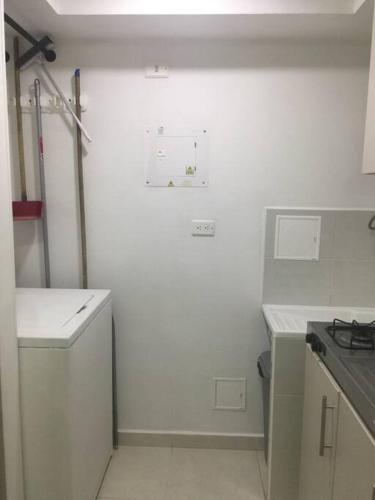 a small kitchen with white walls and a stove at Ideal Apartaestudio con Piscina!!! in Dosquebradas