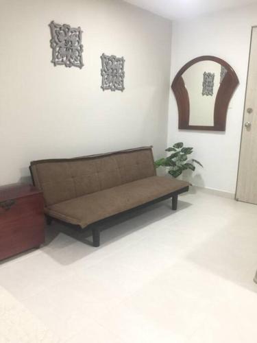 a brown couch sitting in a room at Ideal Apartaestudio con Piscina!!! in Dosquebradas