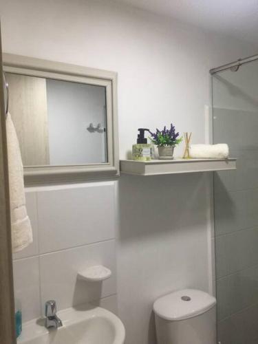a white bathroom with a toilet and a sink at Ideal Apartaestudio con Piscina!!! in Dosquebradas