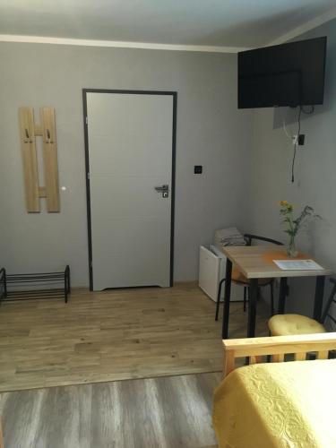 a room with a white door and a table and a tableablish at Słoneczne Wzgórze in Łagów