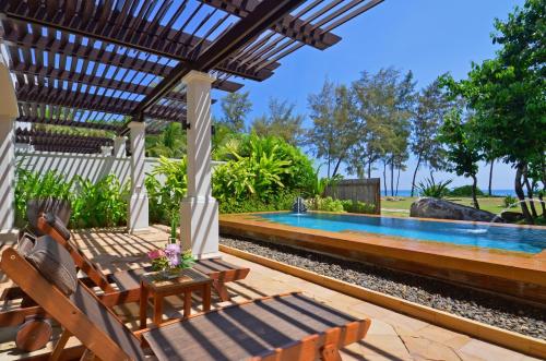 a swimming pool in a backyard with a pergola at JW Marriott Phuket Resort and Spa in Mai Khao Beach