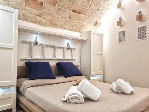 Habitación con 2 camas y almohadas azules. en Monopoli Casa Vacanze, en Monopoli