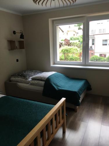 a bedroom with two beds and a window at Słoneczne Wzgórze in Łagów