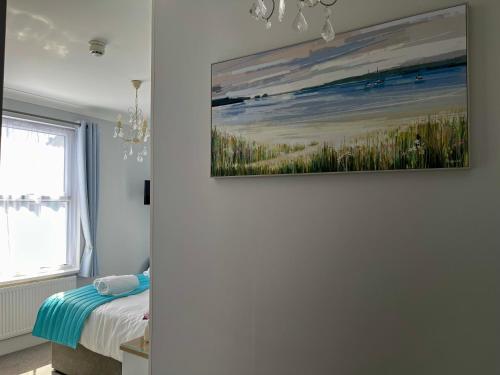 a bedroom with a painting on the wall at Bentley Lodge in Torquay
