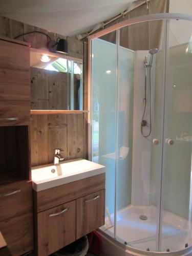 a bathroom with a sink and a shower at Luxe safaritent op Landgoed de Leijen in Hensbroek