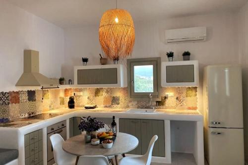 a kitchen with a table and a white refrigerator at Armonia Guesthouse close to Mykonos town in Dexamenes